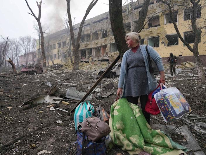 A woman walks outside the damaged by shelling maternity hospital in Mariupol, Ukraine, Wednesday, March 9, 2022.
