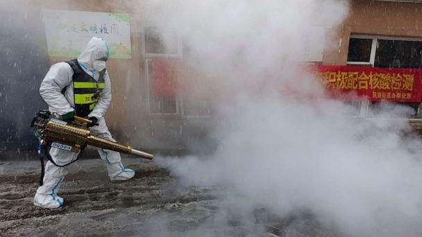 PHOTO: A volunteer disinfects the area as it snows during the COVID-19 lockdown in Changchun in northeast China's Jilin province on March 12, 2022. (Chinatopix Via AP)