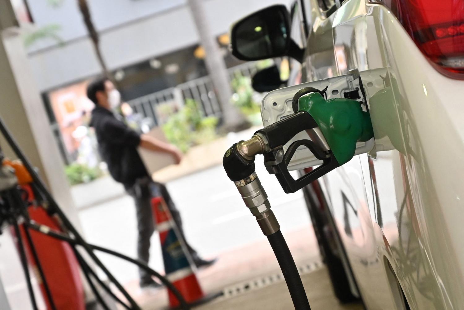 Petrol station attendants fill up vehicles at a service station in Hong Kong this week. Fuel prices have risen substantially worldwide as traders fret over the fallout from Russia's invasion of Ukraine. (Photo: AFP)