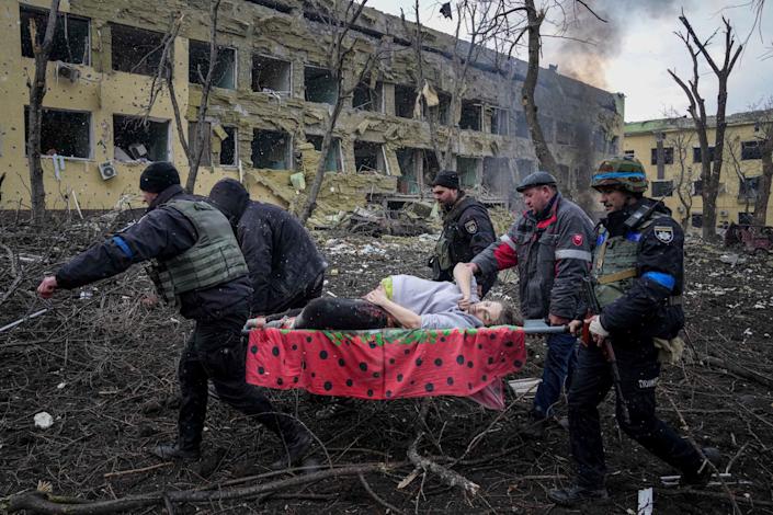 Ukrainian emergency employees and volunteers carry an injured pregnant woman from the maternity hospital that was damaged by shelling in Mariupol, Ukraine, Wednesday, March 9, 2022. The woman and her baby died after Russia bombed the maternity hospital where she was meant to give birth.