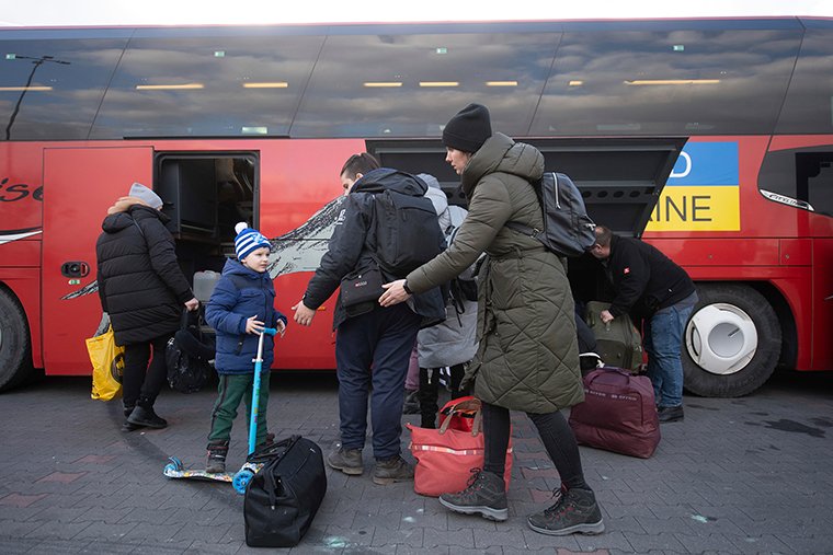 Karolina, who fled Poltava, waits with her son at a distribution center in Przemysl, Poland on March 10, to board a bus heading to Pforzheim.