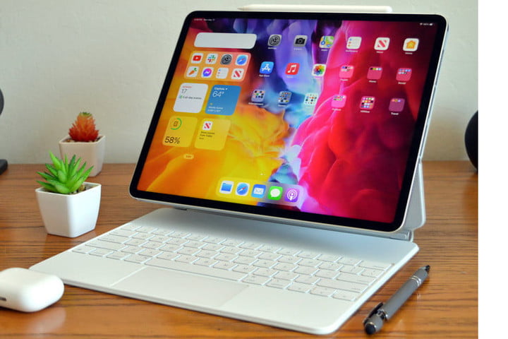 The iPad Pro in silver sits on a table near two plants.