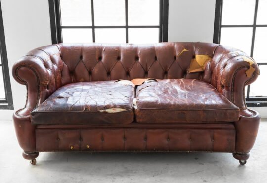 vintage style . Defective old leather sofa on white room