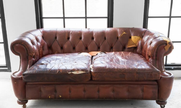 vintage style . Defective old leather sofa on white room